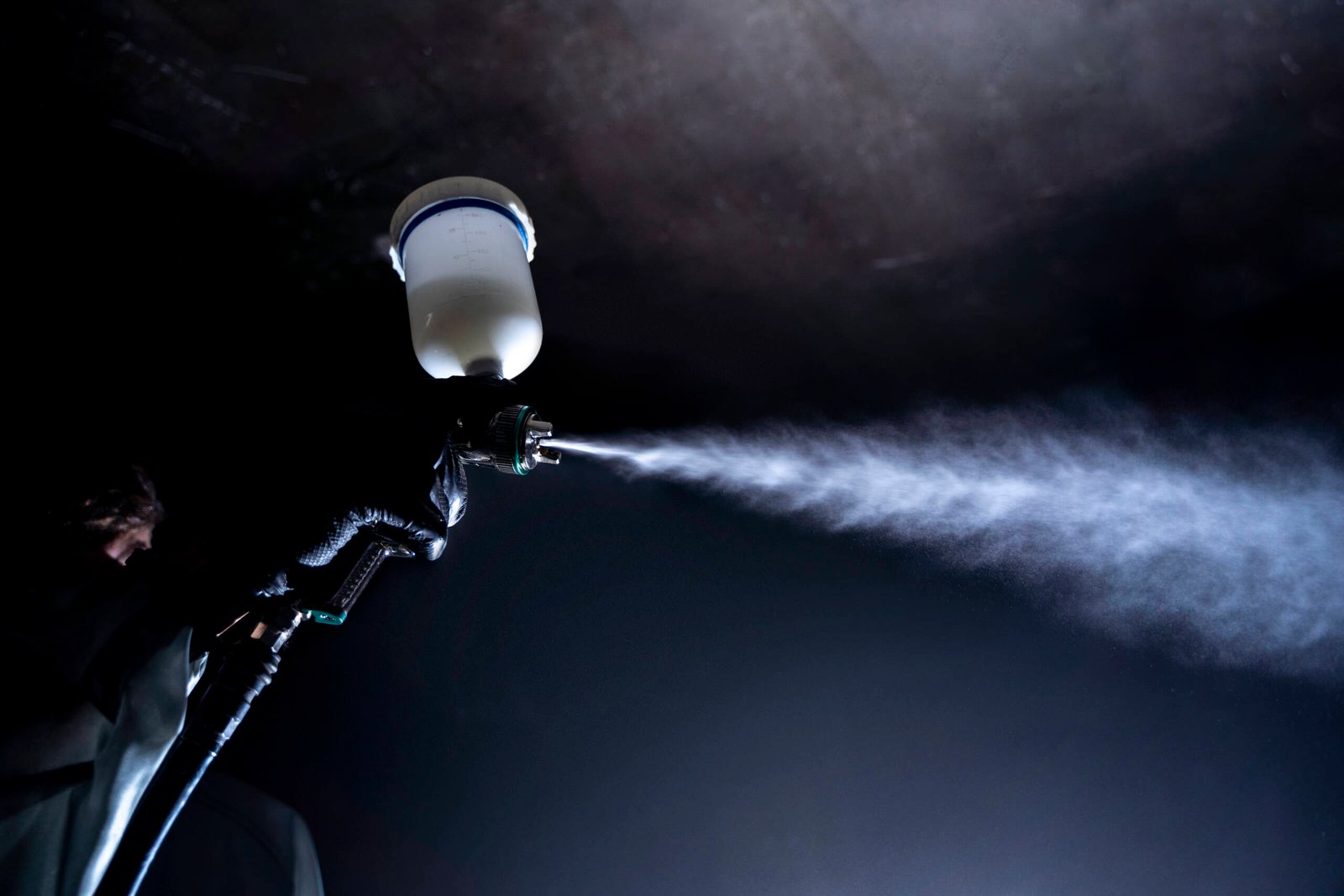 low-angle-worker-spraying-powder-paint-from-gun